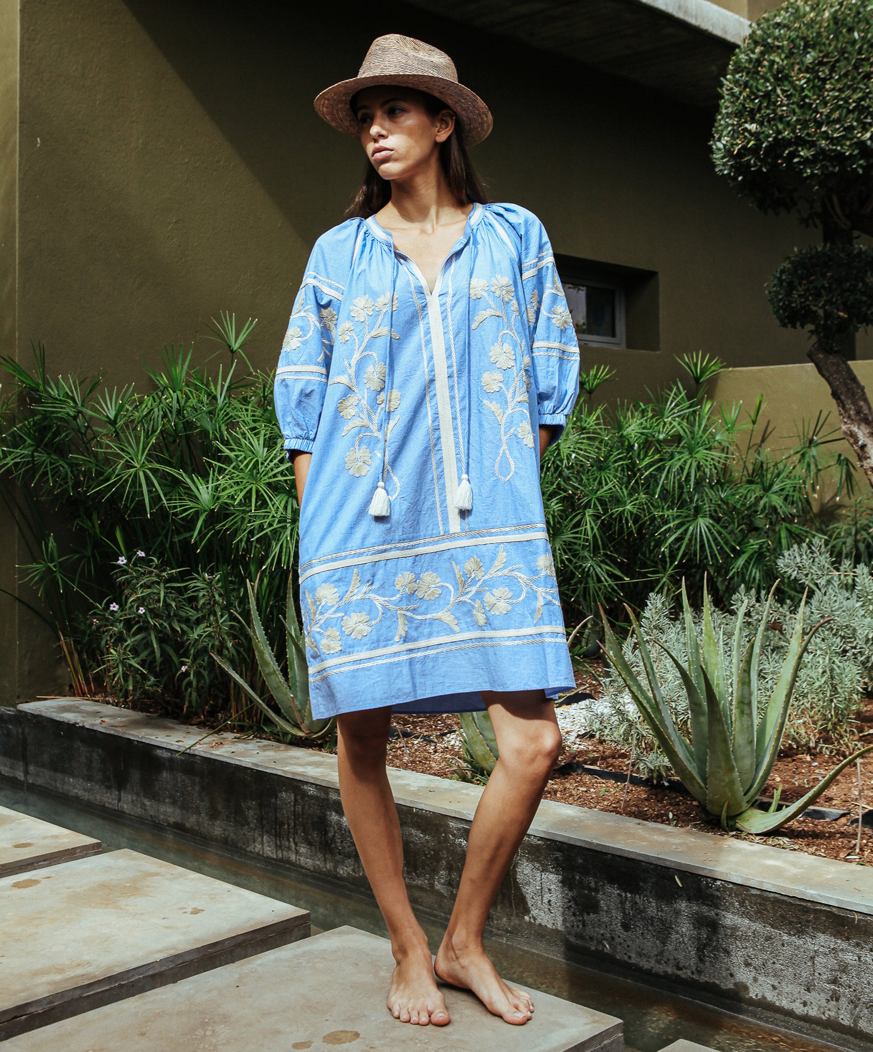 A model wearing a Rose and Rose Camden embroidered dress in blue cotton.