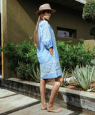 A side view of a model wearing a Rose and Rose Camden embroidered dress in blue cotton.