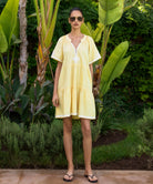 Woman in a yellow dress standing in a garden setting
