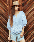 A model wears a Rose and Rose Goldhawk decorative top in blue linen.