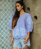 A model wears a Rose and Rose Goldhawk decorative top in blue linen.