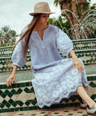 Model wearing a Rose and Rose Grange embroidered dress in blue linen.