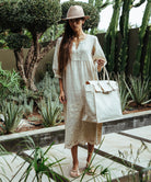 A model wearing a Rose and Rose Grange embroidered dress in natural linen.