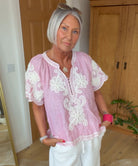 Influencer @simpsonhouse wearing the red striped Azalea top with white embroidery decoration.