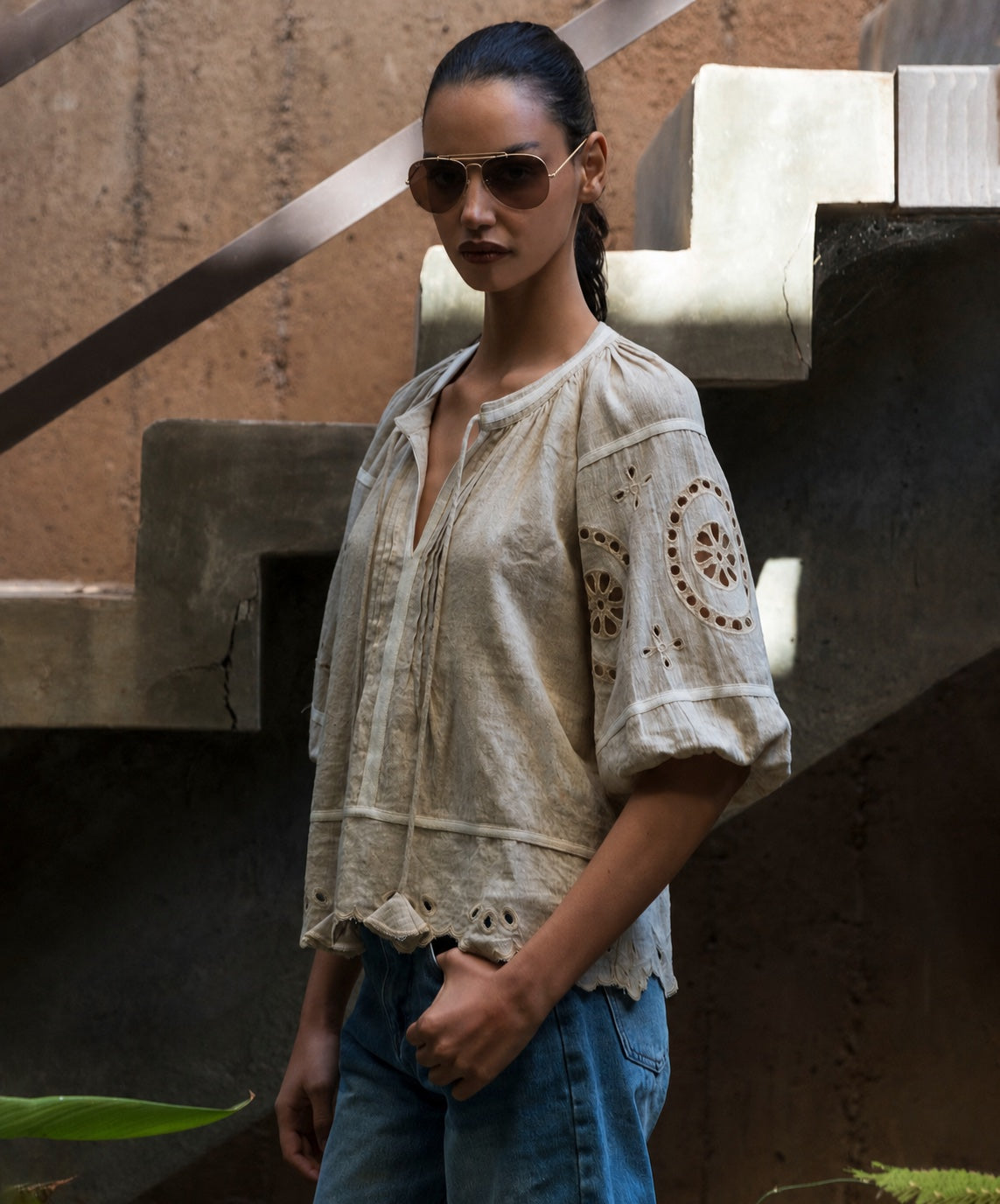 Woman wearing a natural linen blouse with intricate embroidery in an urban setting