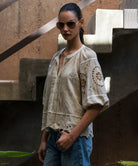 Woman wearing a natural linen blouse with intricate embroidery in an urban setting