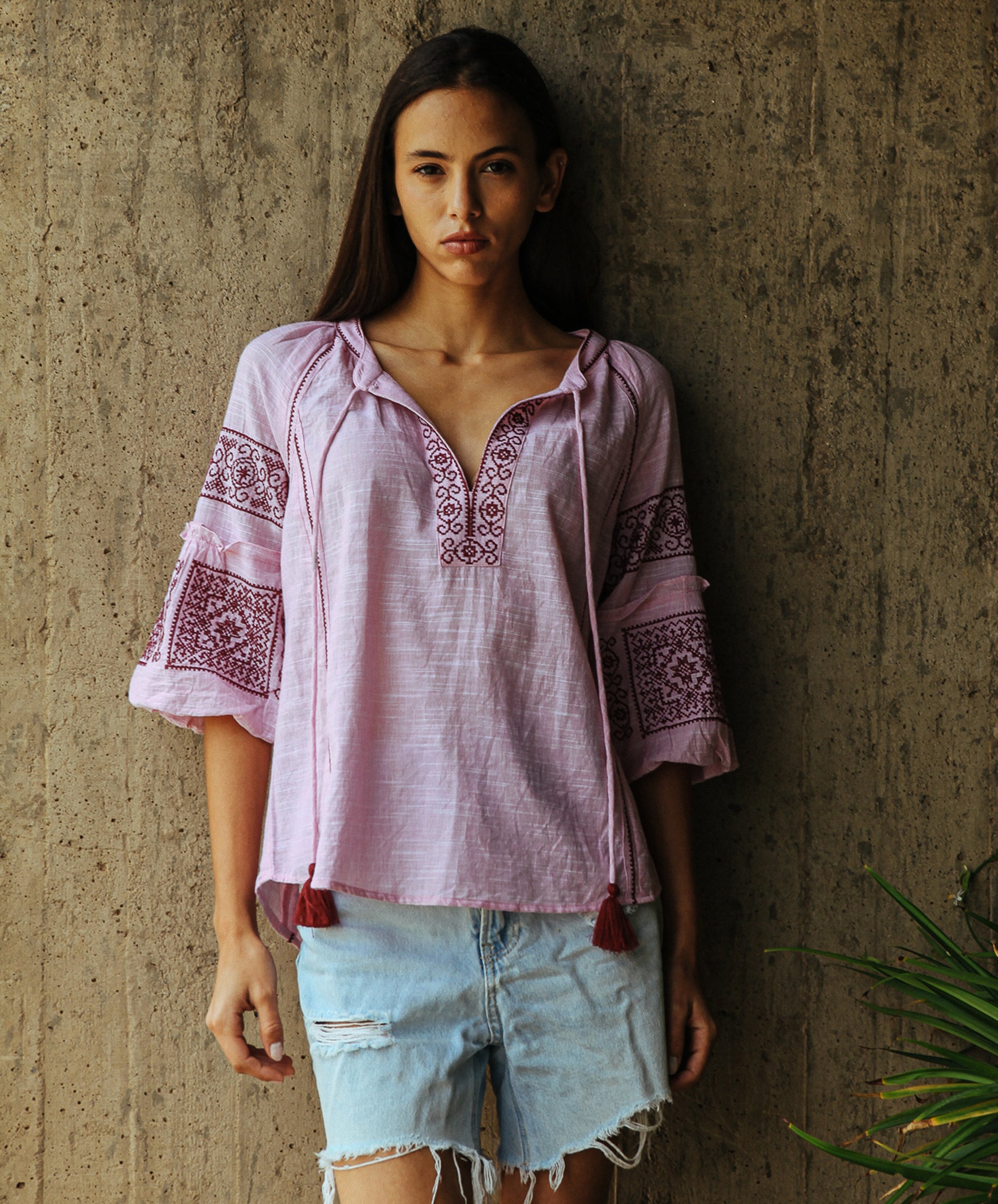 Model wearing a Rose and Rose Newbury embroidered top in pink. 