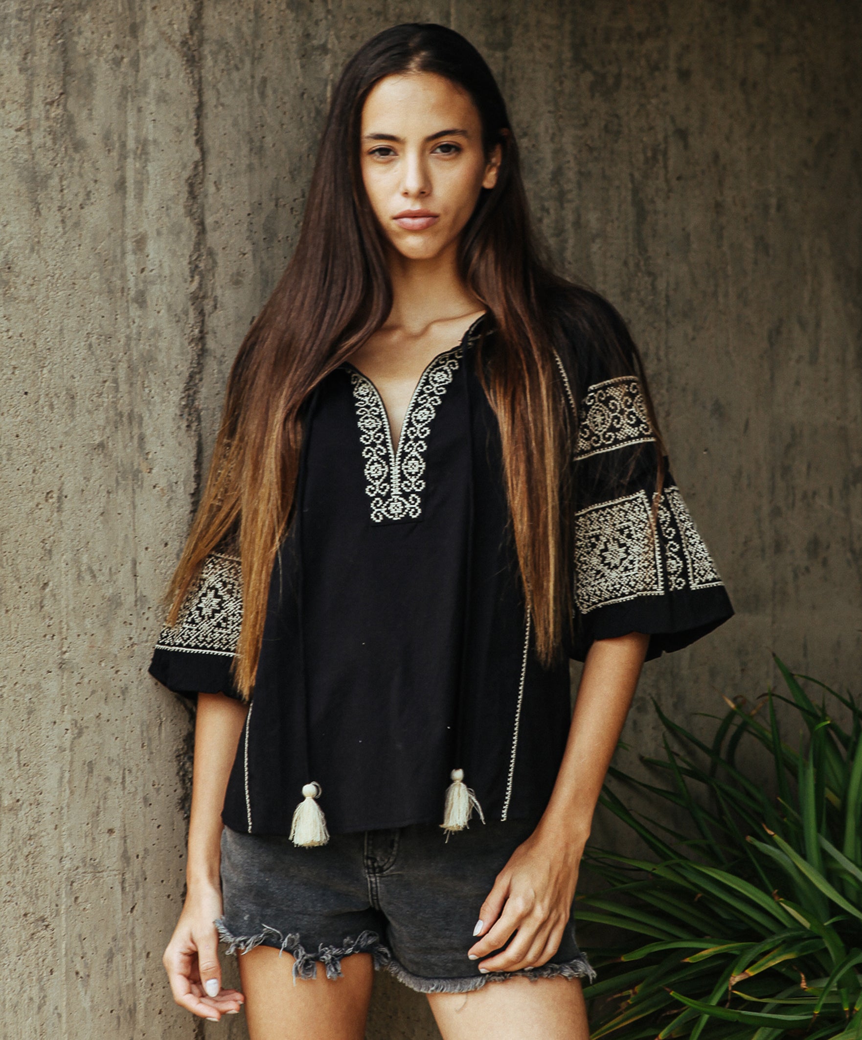 Model wearing a Rose and Rose Newbury embroidered top in black.