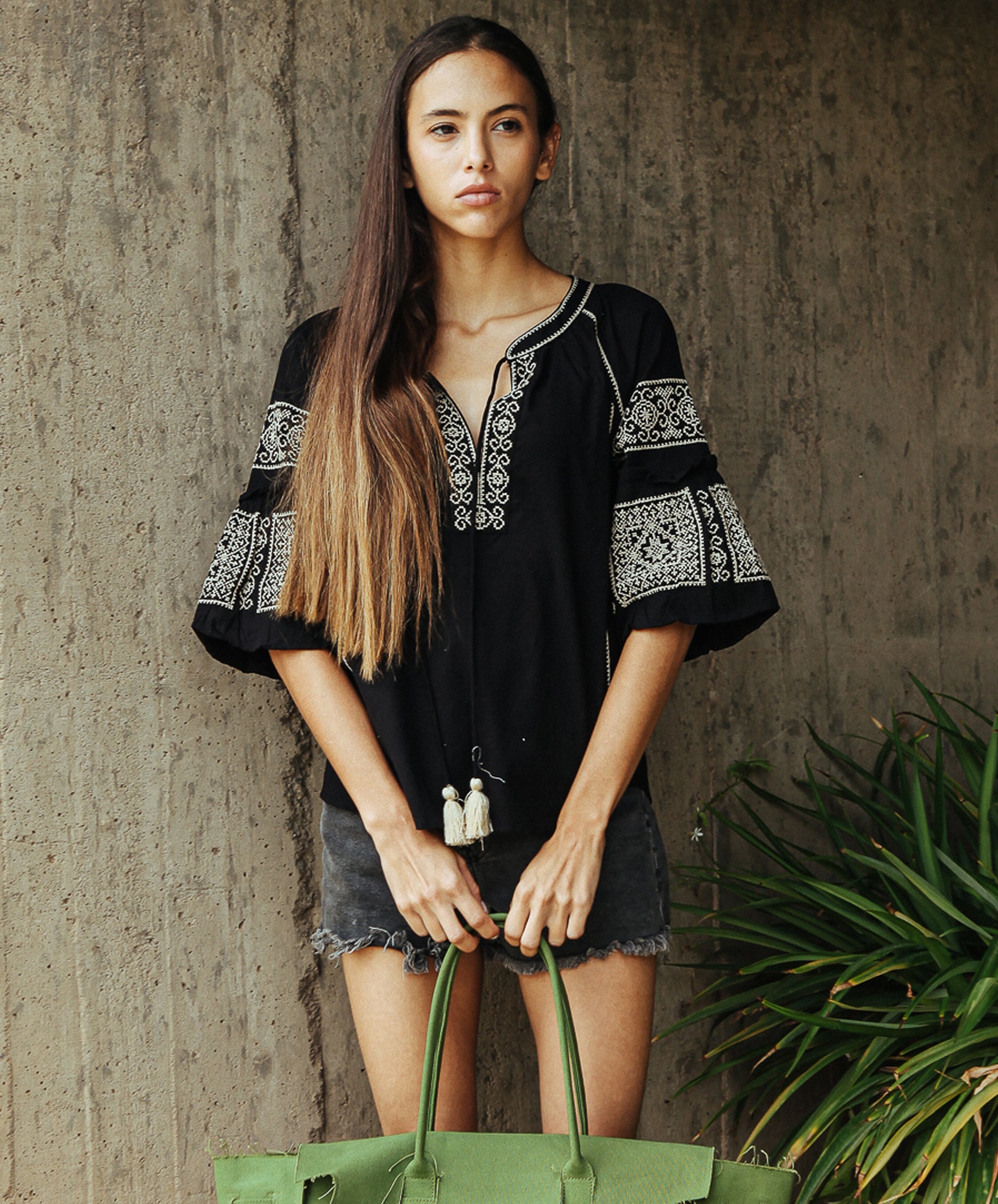 Model wearing a Rose and Rose Newbury embroidered top in black.