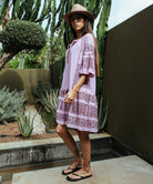 Side view of a model wearing a Rose and Rose embroidered Notting hill pink dress. 