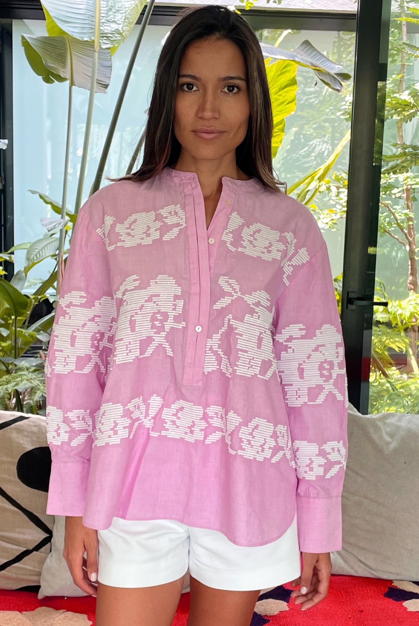A model wearing a Rose and Rose pink Parma shirt and white shorts. 