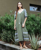 Model wears a Rose and Rose embroidered Royal Oak dress in olive cotton