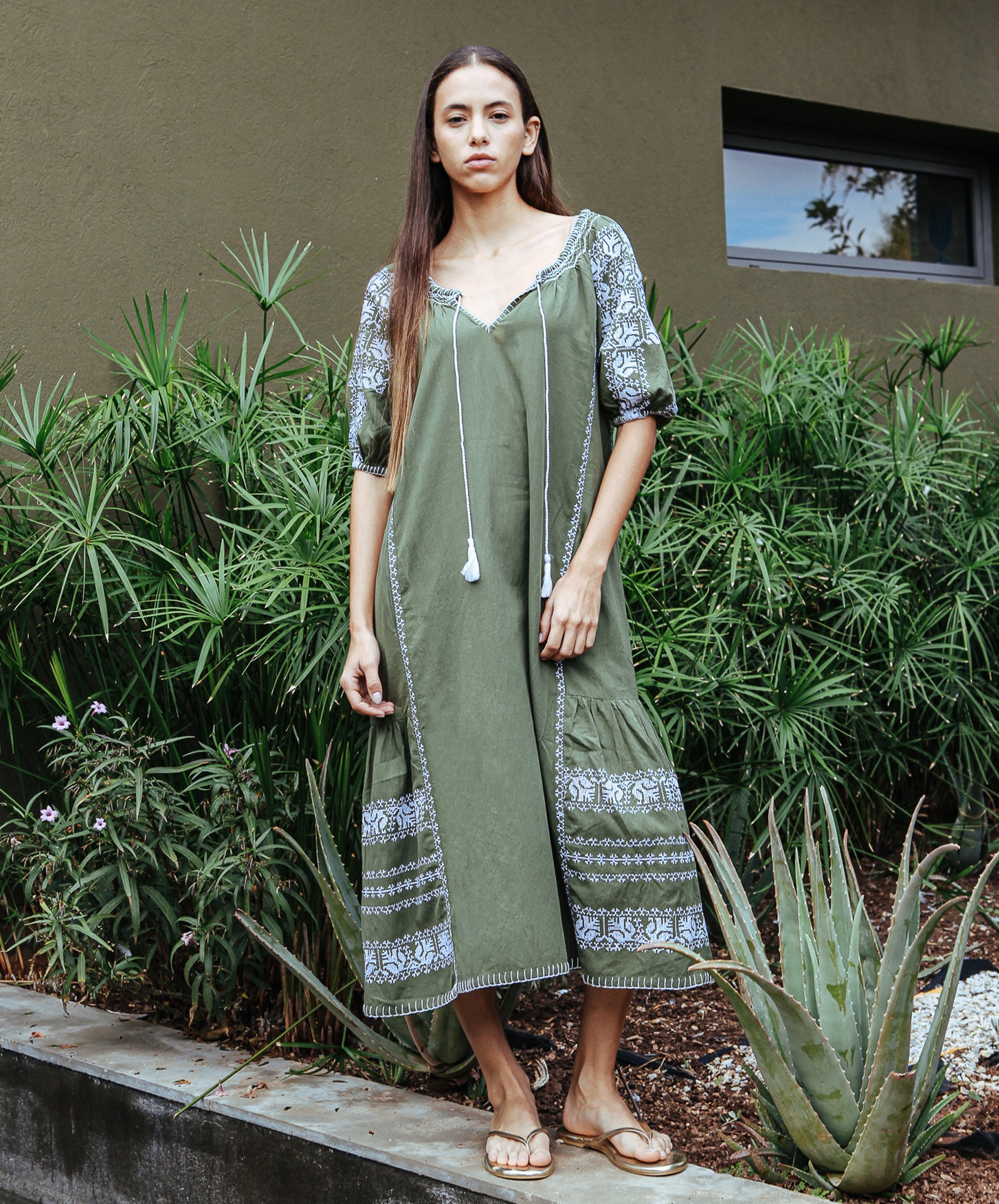 Model wears a Rose and Rose embroidered Royal Oak dress in olive cotton