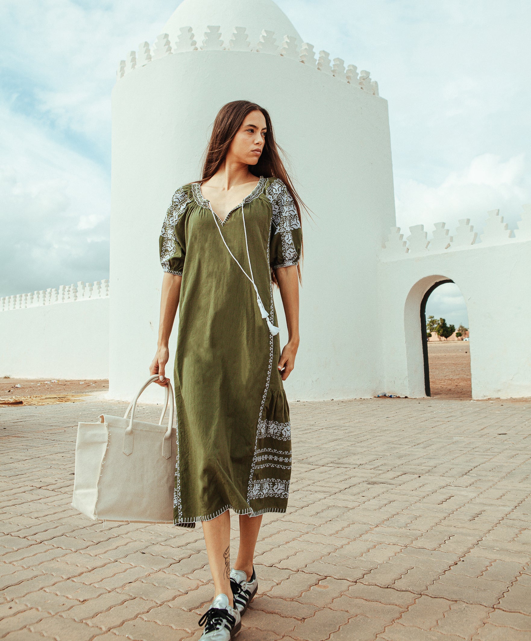 Model wears a Rose and Rose embroidered Royal Oak dress in olive cotton