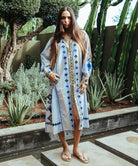 A model stood in a cacti garden wearing a Rose and Rose Temple striped dress with embroidery and sequin decoration.