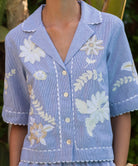 Floral embroidered short-sleeve shirt in blue stripes on a woman