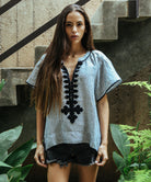 Model wears a Rose and Rose Upminster passementerie decorated top in striped linen.